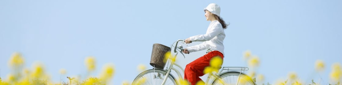 En ung kvinde kører på cykel gennem en sommermark