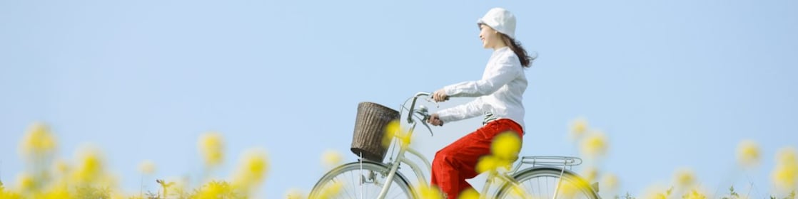 En ung kvinde kører på cykel gennem en sommermark