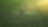 Areial shot of a farmer fertilizing a large green field of crops 