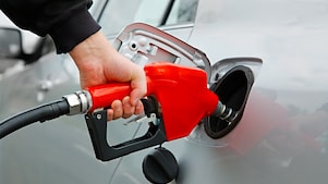 Hand fueling up a car at a gas pump